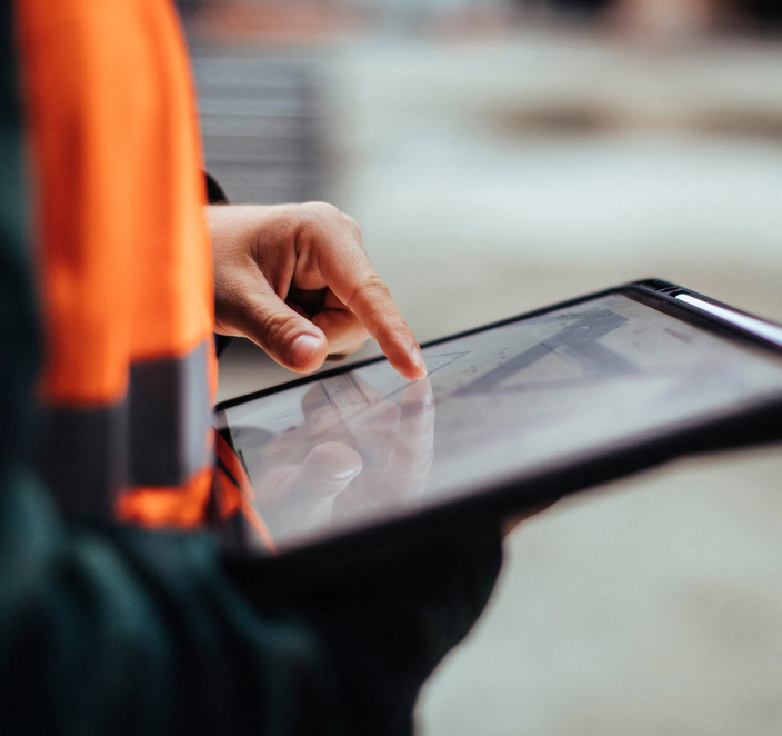 Employee auditing site safety on a tablet.