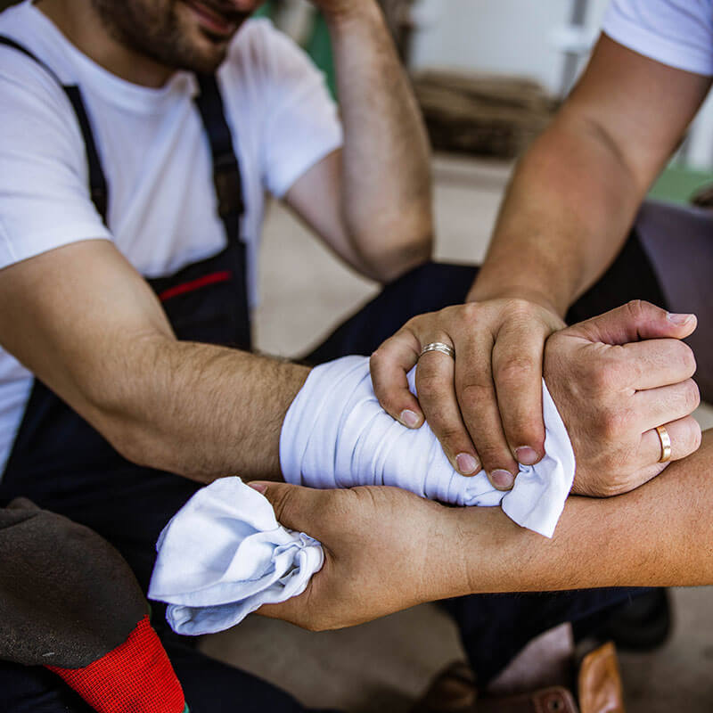 Employee suffering from an arm injury at their worksite and receiving assistance.