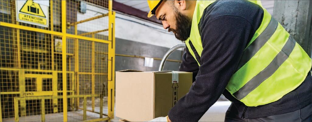 Employee bending over to lift a box