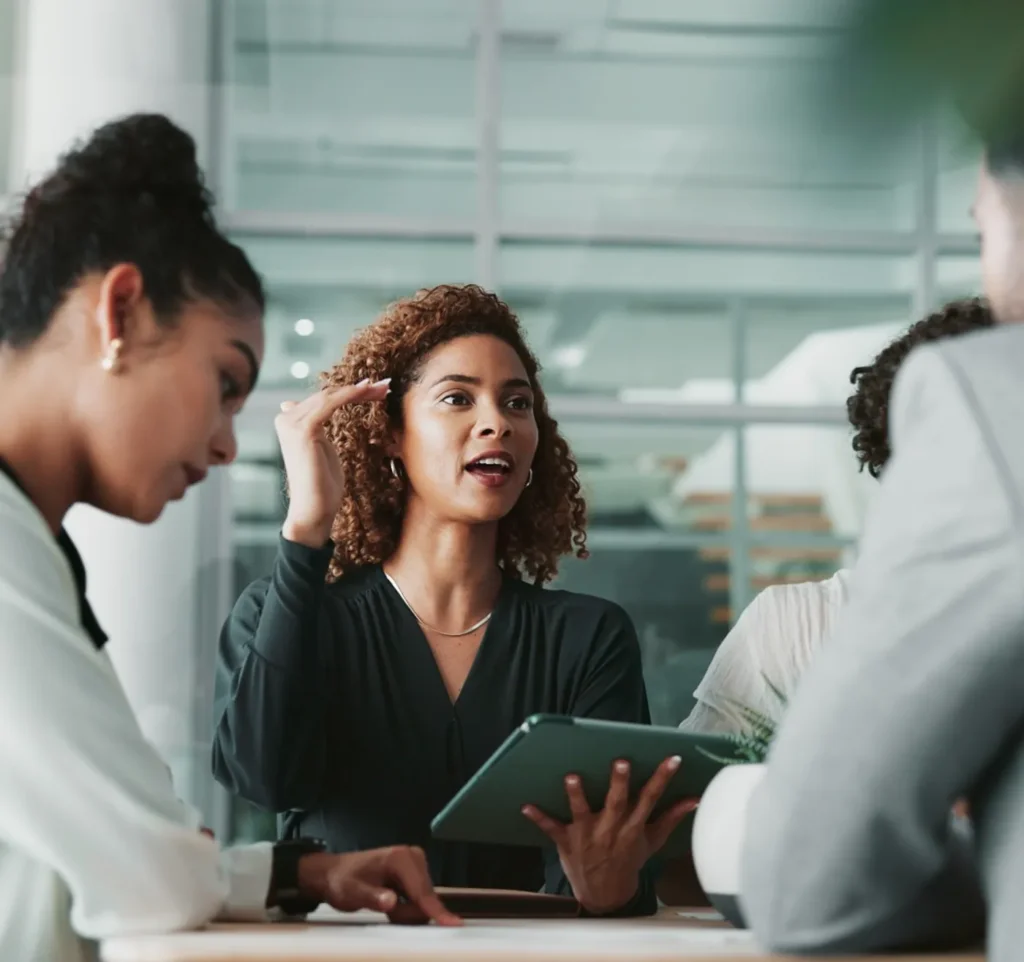 Team meeting with occupational health professional leading discussion using tablet